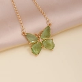 Macro detail of golden butterfly necklace with green zircon crystals on silk fabric - 1# Green Necklace