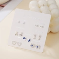 Weekly earring set with 7 pairs of stylish pearl and heart studs on a white card - Pearl Cherry Letter Style (E1992-1)