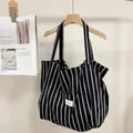 Detalle de un bolso tote de lona a rayas blancas y negras con etiqueta de Bonjour - Rayas Blancas y Negras