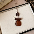 Detail of vintage flower pendant with wooden beads and amber resin on white tray - 15# Brown Square