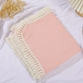 Detailed macro shot of pink double-layer muslin baby blanket with white tassel trim - Large Style / Pink
