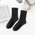 Classic black cotton mid-calf socks for women shown with casual sneakers and a book - One Size / Black