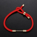 Close-up of adjustable red woven cord bracelet with gold metal accents and sliding knot - Red