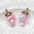 Detail of strawberry-shaped glass pendants with pink and blue star sequins and gold caps - Water Drop / Light Pink