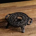 Chauffe-théière rétro en fonte noire avec motifs creux sur une surface en bois vintage - Chauffe-plat Rond 5717