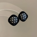 Detalle de pendientes cuadrados de tela con lunares blancos y negros y textura de terciopelo - Estilo de Rombo Negro con Lunares