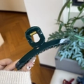 Detail view of large dark green claw clip with gold metal spring for thick hair styling - Malachite green