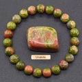 Unakite natural stone beaded bracelet with polished centerpiece on dark background - Unakite