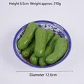 Modelo realista de pepino artificial en un cuenco de porcelana azul y blanca - Luffa Estofada