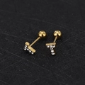 Macro detail of gold-plated T-letter stud earrings with sparkling white cubic zirconia - T Letter - Gold