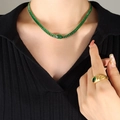 Elegante set collana in oro con zirconi verdi rettangolari su una modella in nero - Collana Verde