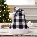 Classic black and white buffalo plaid Christmas hat with plush trim on a wooden table - Black White Grid
