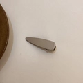 Minimalistische goldene Haarklammer aus Metall mit glatter Politur auf beigem Grund - Praktisches Dreieck