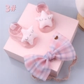 Detail of pink baby socks with plush stars and a matching plaid bow headband - Style 3 (Pink Star/Pink Plaid)