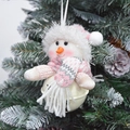 Close-up of plush snowman Christmas bell ornament with pink scarf on tree branch - Pink and White Snowman