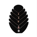 Black velvet tiered jewelry display stand featuring rose gold and silver necklaces - Flame Board Black