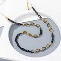 Detail van acryl brillenkoord met zwarte en schildpadschakels op wit frame - Zwart
