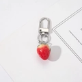 Gros plan détaillé d'un porte-clés fraise en résine réaliste avec boucle en métal argenté - Fraise