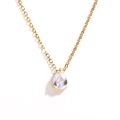 Detailed close-up of golden teardrop zircon pendant on a delicate chain necklace - White Teardrop