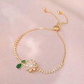 Detail van verstelbare gouden armband met witte zirkoonbloemen en groene edelsteentjes - Smaragd roterende zonnebloem armband