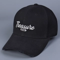 Détail de la broderie blanche Treasure sur une casquette en coton noir avec bord usé - Noir