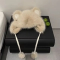 Dettaglio del cappello di peluche a orecchie d'orso beige con lacci a pompon decorativi - Cachi Scuro
