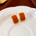 Close-up of vintage square oil-dripping stud earrings on a decorative ceramic plate - Silver Pin - Orange Drip Oil Square Stud Earrings