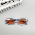 Dettaglio degli occhiali da sole cat-eye blu con lenti arancioni e specifiche sulla stanghetta - Montatura Nera Lenti Arancio Rosso