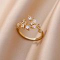 Detailed close-up of 18K gold-plated leaf ring with sparkling zircon on silk background - Leaf Branch With Zirconia Style (G3014406)