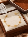 Detail of adjustable gold stainless steel daisy chain bracelet on a linen display tray - Gold 5-Daisy Flower Fine Chain Bracelet