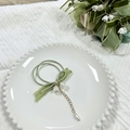 Chouchou vert avec pendentif muguet et nœud en soie sur une assiette blanche - Style Ruban Court / Vert
