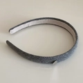 Détail d'un serre-tête en tricot gris avec un petit pendentif en métal en forme de cœur - Gris foncé