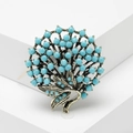 Vintage bronze brooch with turquoise beads in a floral tree design on a white pedestal - Turquoise Blue