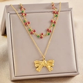 Close-up of double-layer necklace with red cherry charms and gold bow pendant - Bowknot Style