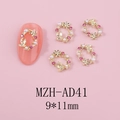 Détail macro du charm nail art couronne dorée avec strass roses et perles blanches - Style Ovale Rose Or (AD41)