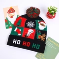 Detail of Christmas knitted hat with HO HO HO text and festive holiday pom-pom - Black Plaid Christmas Elements