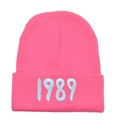 Detailed view of the bright pink knit beanie featuring white 1989 number embroidery - Adult (Stretchy) / Watermelon red