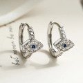 Silberne Creolen mit bösem Blick, blauem Zirkon und Pavé-Steinen auf beiger Karte - Silber