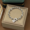 Detalle de la pulsera de cadena gruesa plateada con colgante de corazón y cierre de barra - Hebilla OT Corazón Acero