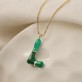 Dettaglio macro della collana con ciondolo lettera L, smalto verde e placcato oro - L