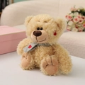 Beige plush teddy bear wearing a grey knitted scarf with heart patterns - Khaki Bear / 27cm