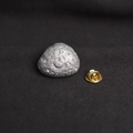 Silver metal meteorite brooch with cratered texture and golden butterfly clasp back - Meteorite Shape