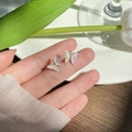 Hand holding iridescent butterfly stud earrings with purple and pink gradient butterfly wings - EQ-71 Iridescent White Butterfly