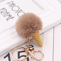 Detail view of a fluffy brown faux fur ice cream cone keychain with golden metal hardware - Khaki