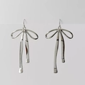 Minimalist silver bow earrings with long metal ribbons in a sleek studio shot - Silver