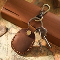 Brown leather AirTag case keychain with fine stitching and antique bronze hook - Brown