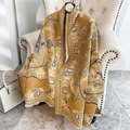 Ginger yellow cashmere feel scarf with blue paisley pattern and tassel trim on chair - Yellow