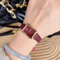 Elegant rectangular gold watch with dark red leather strap and red dial worn by model - Square No Scale Dial
