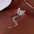 Detailed macro of a silver zircon butterfly tassel clip earring on elegant brown silk - Left Ear Silver Style (HE21589)
