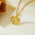 Detail of a gold heart-shaped pendant with multicolor zircon stones on beige fabric - Gold Heart Colorful Hollow Zircon Necklace (T021)
